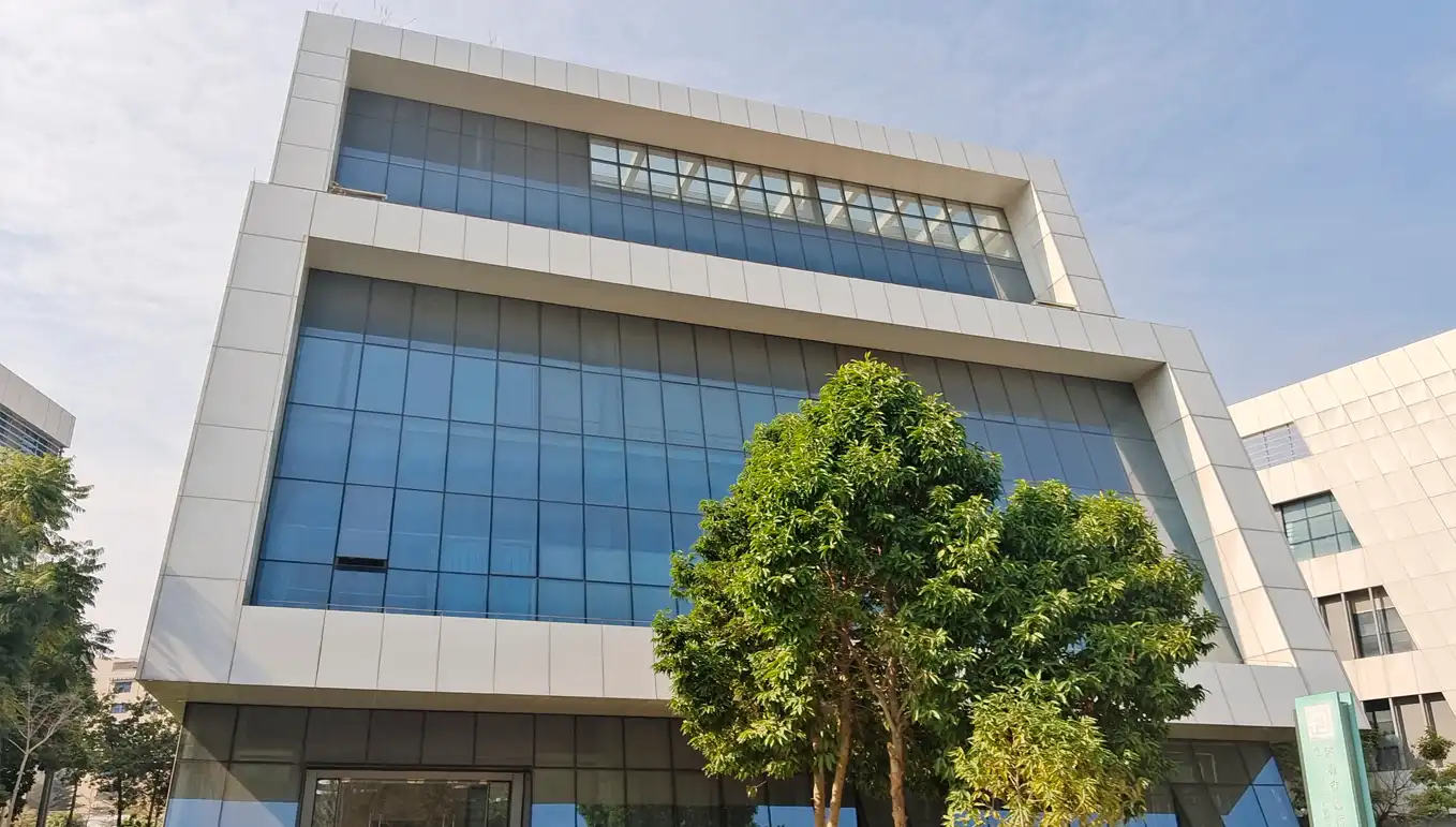 Modern-Office-Building-at-JYMedTech-Shenzhen-Facility Front view of JYMedTech’s modern Shenzhen facility with glass exterior and surrounding greenery